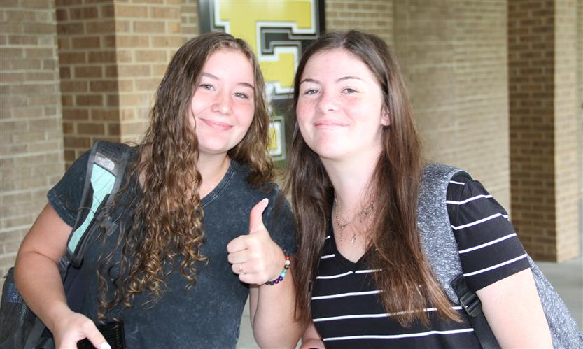 Two students smile